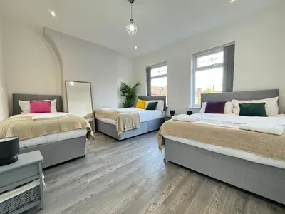 a bedroom with two beds and a mirror at Now Screening…Large Movie Place 60 Inch TV (Sleep 11) in Liverpool