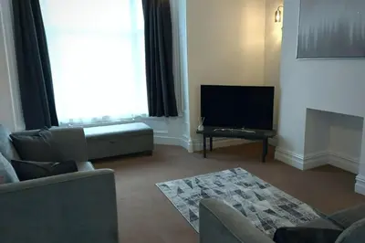 a living room with a couch and a flat screen tv at 2 Bedroom City Centre Duplex Apt in Preston
