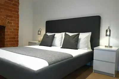 a bedroom with a large bed and a brick wall at 2 Bedroom City Centre Duplex Apt in Preston