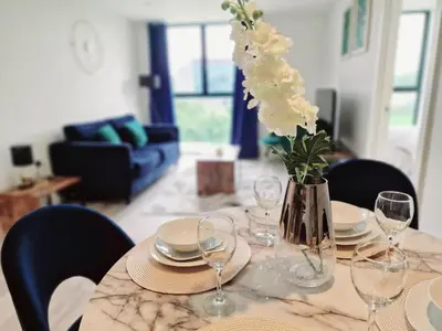 a table with plates and a vase with flowers on it at Westminster Luxury Liverpool Apartment with Free Parking in Liverpool