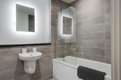 a bathroom with a sink and a toilet and a bath tub at Westminster Luxury Liverpool Apartment with Free Parking in Liverpool