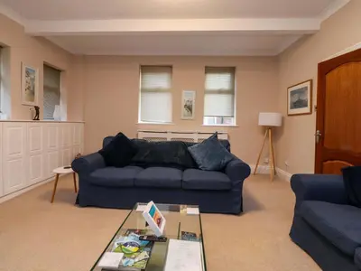 a living room with a blue couch and a table at 6D Clifton Drive in Lytham St Annes