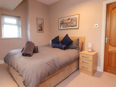 a bedroom with a large bed with a night stand at 6D Clifton Drive in Lytham St Annes