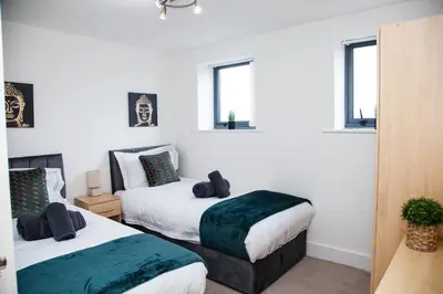 two beds in a room with white walls and windows at Penthouse - Liverpool City Centre - NHS STAYS - Liverpool Royal Hospital in Liverpool