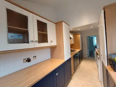 a kitchen with white cabinets and a blue counter top at 4 Bed house Sea Views Benji's by the beach in Morecambe