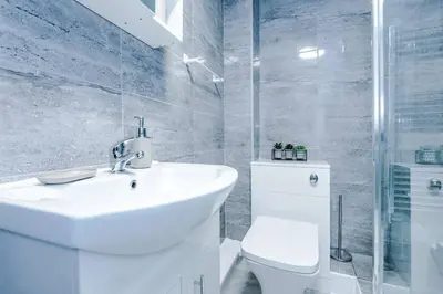 a white bathroom with a sink and a toilet at 5 Sleeper LFC Themed Apartment in Liverpool