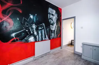 a room with a large painting on the wall at 5 Sleeper LFC Themed Apartment in Liverpool