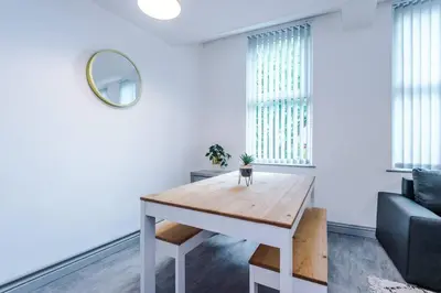 a living room with a table and a couch at 5 Sleeper LFC Themed Apartment in Liverpool
