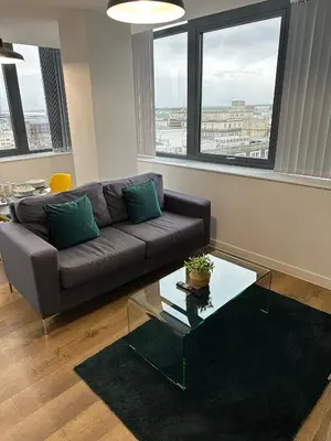 a living room with a couch and a glass table at Stunning City View Apartment by Central Stay in Liverpool