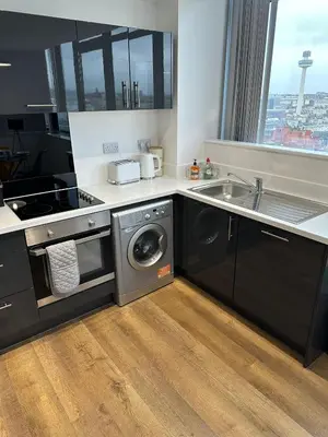 a kitchen with a sink and a washing machine at Stunning City View Apartment by Central Stay in Liverpool