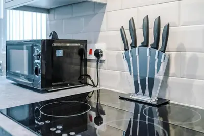 a kitchen with a counter with a knife block on it at LFC Themed Apartment in Liverpool