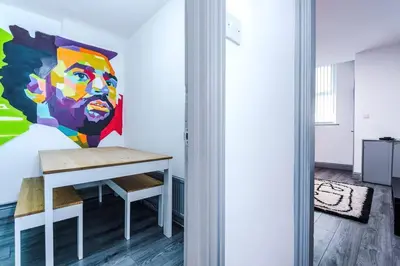 a room with a table and a painting on the wall at LFC Themed Apartment in Liverpool