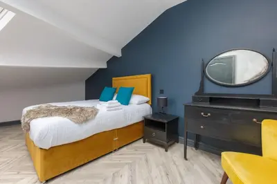 a bedroom with a bed with a mirror and a dresser at GiGi's in Blackpool