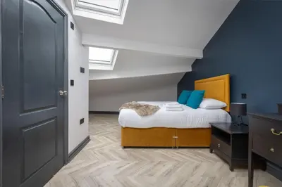 a bedroom with a bed with blue walls at GiGi's in Blackpool
