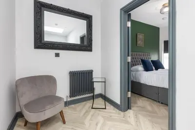 a bedroom with a mirror and a chair and a bed at GiGi's in Blackpool