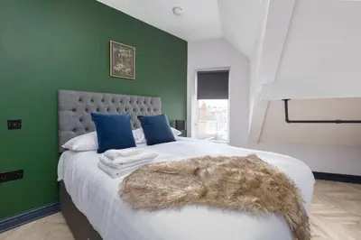 a bedroom with a large bed with a green wall at GiGi's in Blackpool