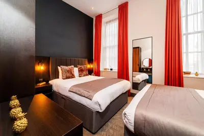 a hotel room with two beds and red curtains at Duke Street Townhouse by EPIC in Liverpool