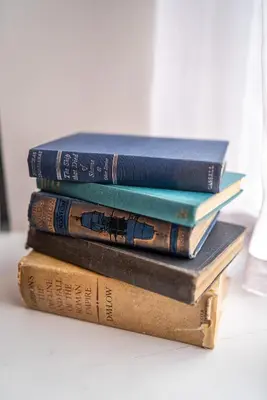 four books stacked on top of each other on a table at Duke Street Townhouse by EPIC in Liverpool