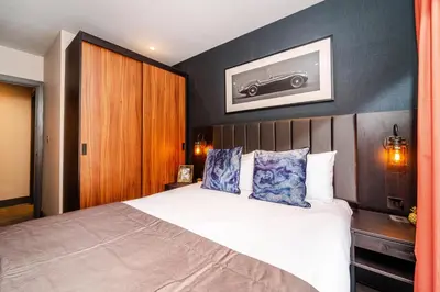 a bedroom with a bed and a picture of a car on the wall at Duke Street Townhouse by EPIC in Liverpool