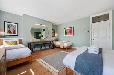a bedroom with two beds and a desk and a mirror at Host & Stay - Upper Duke Street Apartment in Liverpool