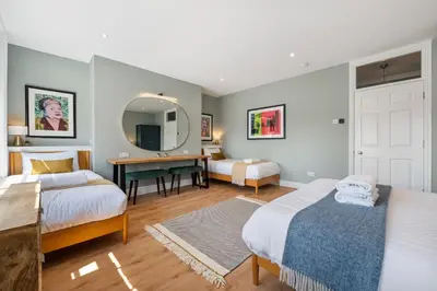 a bedroom with two beds and a desk and a mirror at Host & Stay - Upper Duke Street Apartment in Liverpool