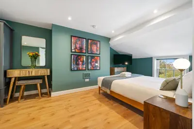 a bedroom with green walls and a bed and a desk at Host & Stay - Upper Duke Street Apartment in Liverpool