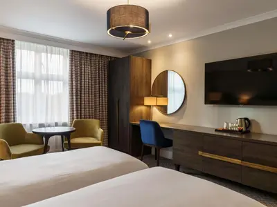 a hotel room with a bed and a table and chairs at Mercure Blackburn Dunkenhalgh Hotel & Spa in Blackburn
