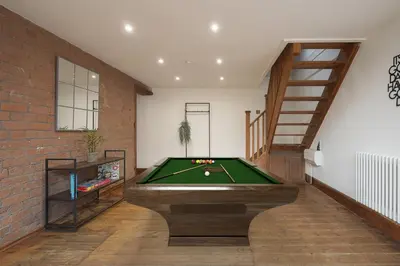 a room with a pool table and a brick wall at Modern 5BR Victorian Home in Liverpool in Knowsley