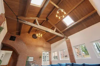 a living room with wooden ceilings and a blue couch at Modern 5BR Victorian Home in Liverpool in Knowsley