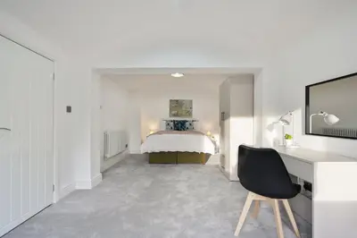 a bedroom with a bed and a desk with a chair at Modern 5BR Victorian Home in Liverpool in Knowsley
