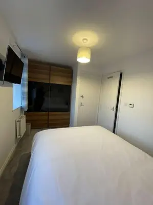 a bedroom with a white bed and a television at Tootle Drive in Longridge