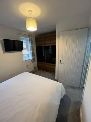 a bedroom with a large white bed and a window at Tootle Drive in Longridge