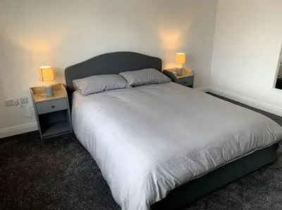 a bedroom with a large bed with two night stands at New large 2 bedroom apartment with private parking in Lea Town