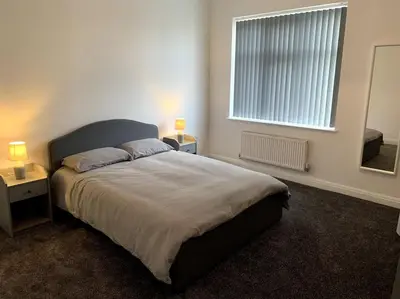a bedroom with a large bed and a window at New large 2 bedroom apartment with private parking in Lea Town