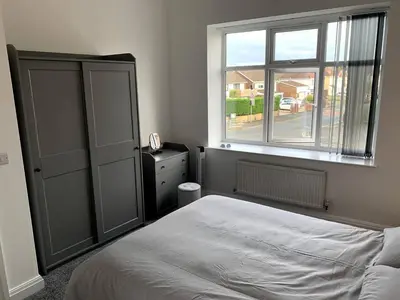 a bedroom with a bed and a window at New large 2 bedroom apartment with private parking in Lea Town