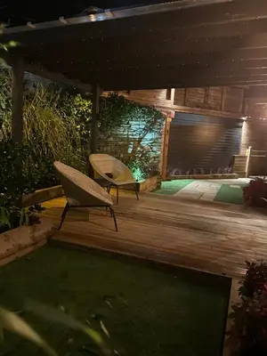 a patio with two chairs on a wooden deck at The Cottage Hideout in Upholland
