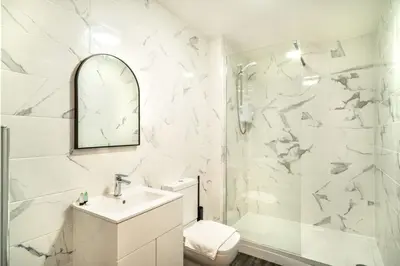a white bathroom with a sink and a shower at Spacious 2 Bed Apartment in Waterloo Liverpool in Waterloo