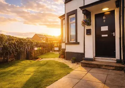 a house with a black door and a yard at Kop View in Liverpool
