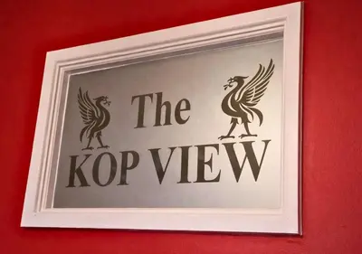 a picture of a sign on a red wall at Kop View in Liverpool