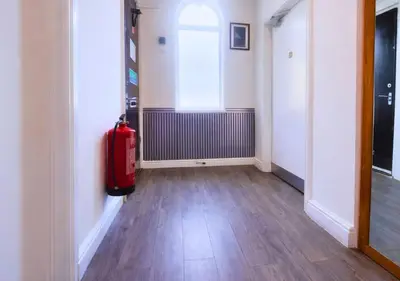 an empty hallway with a red suitcase in a room at Kop View in Liverpool