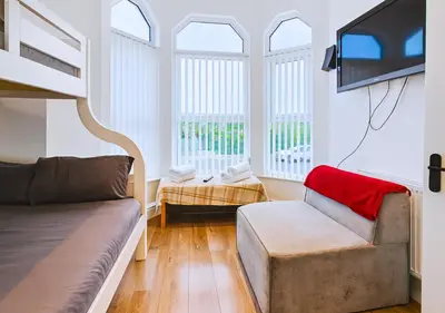a living room with a couch and a tv at Kop View in Liverpool
