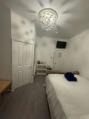 a bedroom with a bed and a chandelier at Valencia in Blackpool