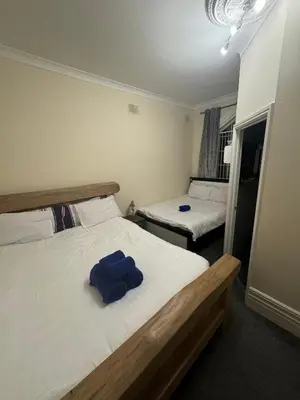 a bedroom with two beds and a blue towel on the bed at Valencia in Blackpool