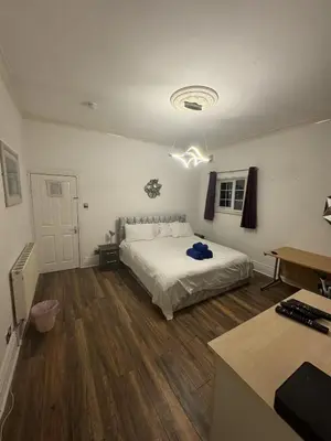 a bedroom with a white bed and a desk at Valencia in Blackpool