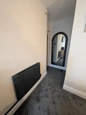 a room with a wall with a mirror and a radiator at Hesketh Hotel in Blackpool
