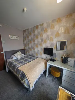 a bedroom with a bed and a desk with a computer at Hesketh Hotel in Blackpool