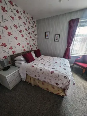 a bedroom with a bed with a floral wallpaper at Hesketh Hotel in Blackpool
