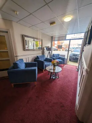 a living room with blue couches and a table at Hesketh Hotel in Blackpool