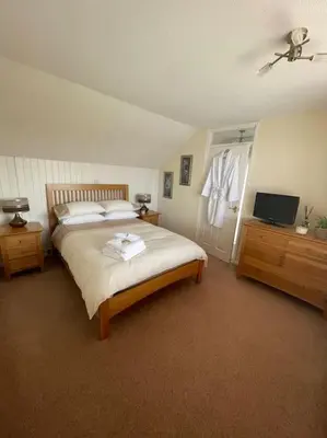 a bedroom with a large bed and a television at Fylde Coast Stays - Home from Home in Freckleton