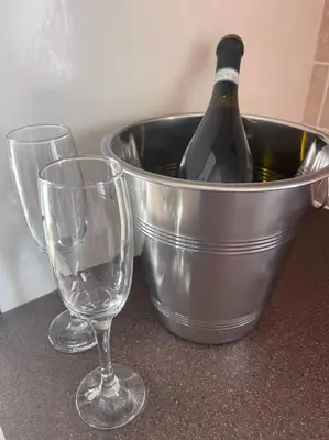 two wine glasses and a bucket with a bottle of wine at Fylde Coast Stays - Home from Home in Freckleton